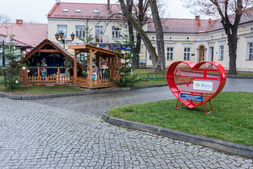 Pojemnik na nakrętki stojący obok szopki bożonarodzeniowej