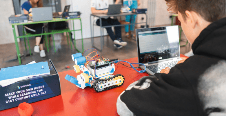 Grafika przedstawiająca zajęcia edukacyjne z robotyki.